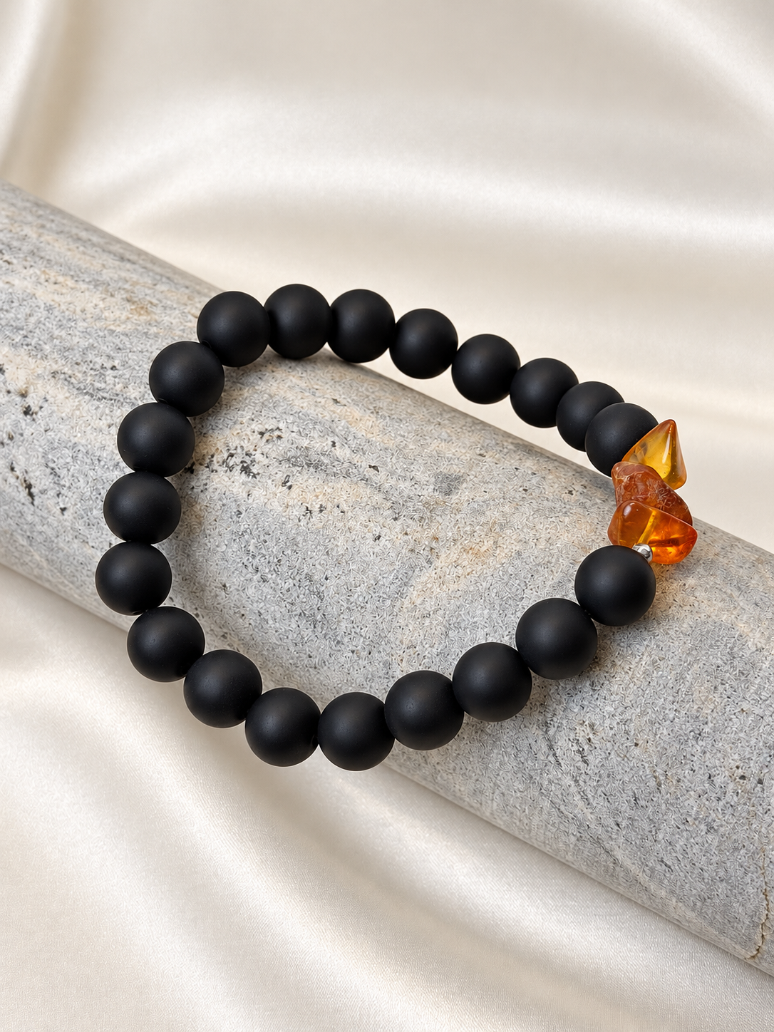 A handmade bracelet featuring matte onyx beads and warm amber-coloured accents. A minimalist design with a distinctive touch for everyday wear.

Stone size: 10 mm
Bracelet size: 20.5–21 cm