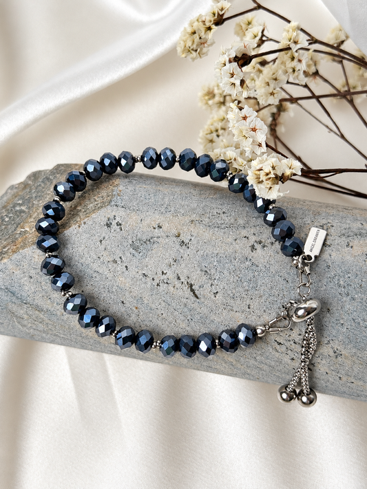 A handmade bracelet featuring faceted glass crystal beads in deep midnight blue with a metallic shimmer, complemented by silver-tone details. An elegant design, perfect worn alone or layered with other bracelets.

Bead size: 6 mm
Bracelet length: approximately 17 cm + 3.5 cm extension chain