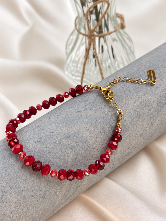 A handmade bracelet featuring rich red shades and gold-tone details. Faceted beads in different sizes catch the light beautifully, adding a subtle sparkle. An elegant accent for everyday wear or special occasions, worn alone or layered with other bracelets.

Length: 18 cm + 5 cm extension chain, adjustable from 18 to 23 cm. Finished with a lobster clasp.