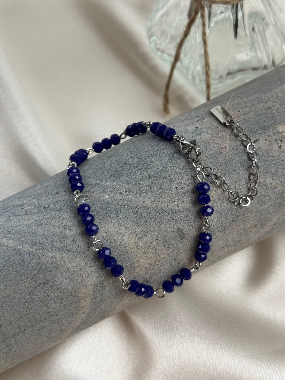 A delicate handmade bracelet featuring rich cobalt-blue faceted beads arranged in groups of three and joined by silver-tone links. The beads catch the light subtly, bringing a touch of colour and elegance to everyday outfits or special occasions. Beautiful worn alone or layered with other bracelets.

Length from 18 to 23 cm.