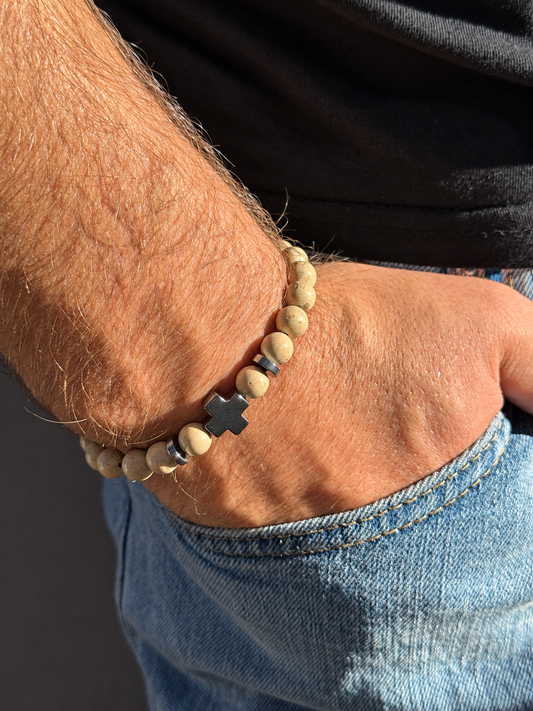 A handmade bracelet featuring stone in warm beige tones, complemented by hematite accents and a distinctive hematite cross. A simple, earthy design, perfect worn alone or stacked with other bracelets.

Stone size: 8 mm
Bracelet size: approximately 19–19.5 cm