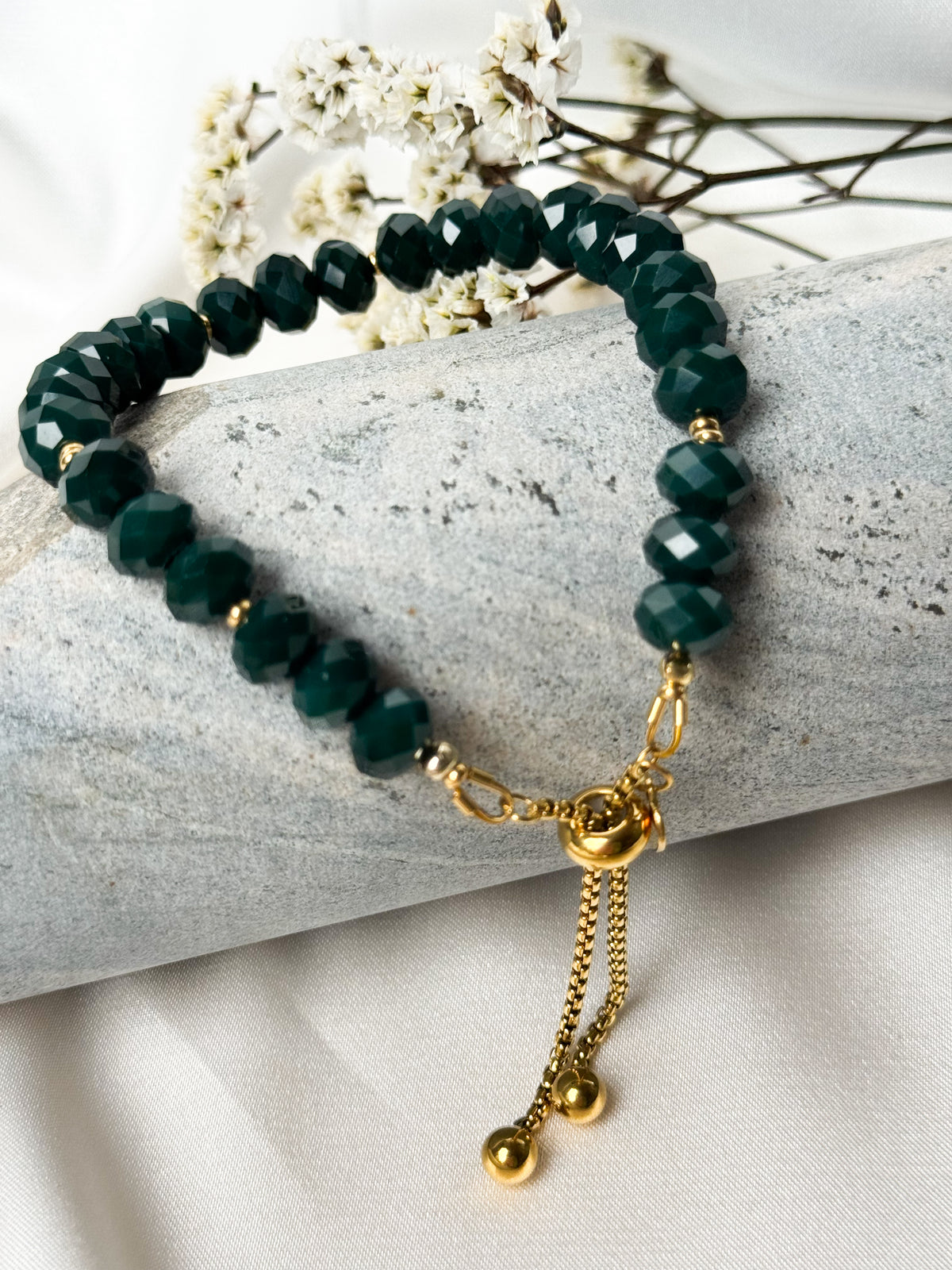 A handmade bracelet featuring faceted glass crystal beads in deep green, complemented by gold-tone stainless steel details. An elegant design with a subtle sparkle and an adjustable chain for a comfortable fit.

Bead size: 8 mm
Bracelet length: approximately 18 cm + 4 cm extension chain