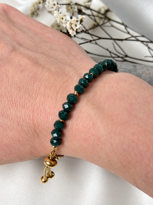 A handmade bracelet featuring delicate faceted glass crystal beads in deep green, complemented by gold-tone stainless steel details. A refined design with a subtle sparkle and an adjustable chain for a comfortable fit.

Bead size: 6 mm
Bracelet length: approximately 17 cm + 4 cm extension chain