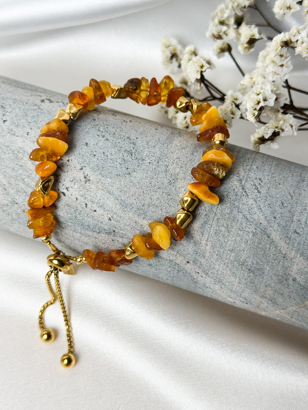 A handmade bracelet featuring amber pieces in warm honey shades, complemented by gold-tone accents. An elegant design with an adjustable fit for everyday wear.

Bracelet length: approximately 18 cm
Extension chain: 4.5 cm