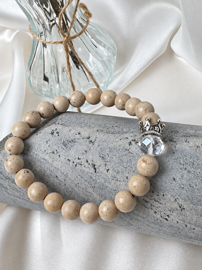 A handmade bracelet featuring stone in warm beige tones, a clear faceted accent and a silver-tone crown detail. An elegant design, perfect worn alone or stacked with other bracelets.

Stone size: 8 mm
Bracelet size: approximately 18 cm