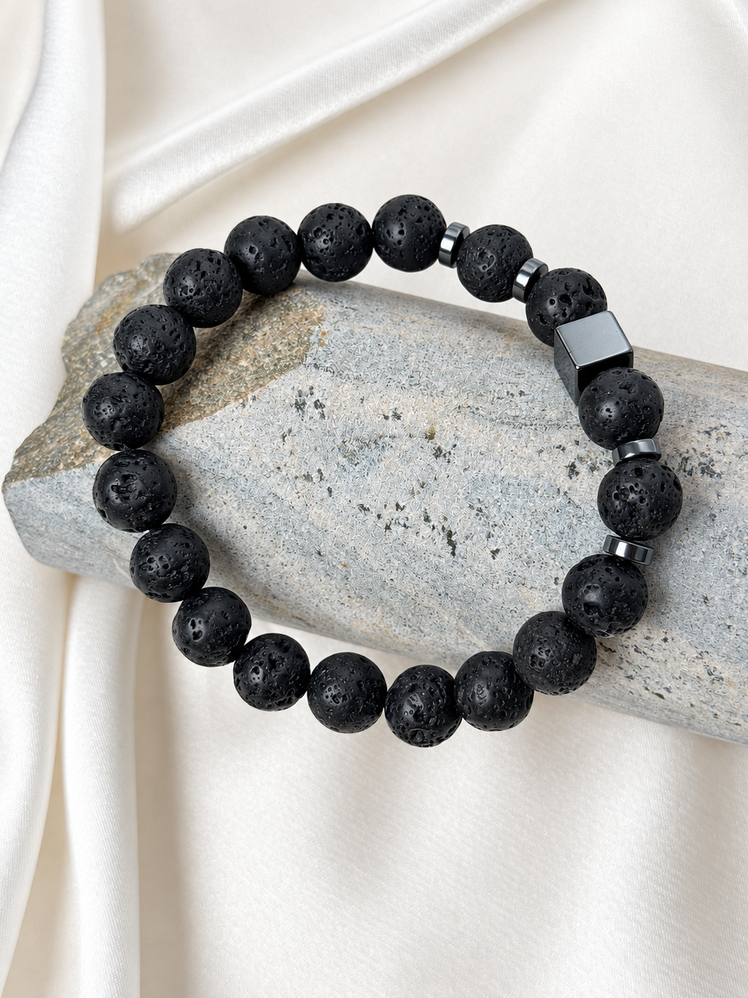 Lava Edge Bracelet

A handmade bracelet featuring textured lava stone and polished hematite accents. A bold, minimalist design with a distinctive cube detail for everyday wear.

Stone size: 10 mm
Bracelet size: 20.5–21 cm