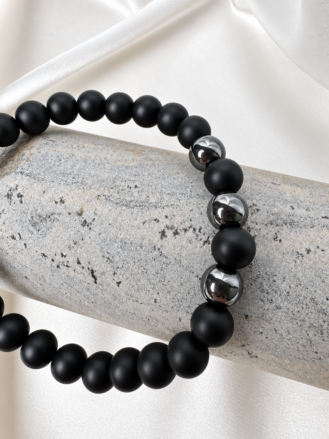 A handmade bracelet featuring matte onyx and polished hematite accents. A minimalist design combining deep black tones with a subtle metallic shine for everyday wear.