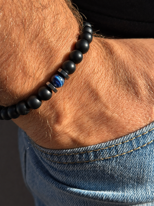 A handmade bracelet featuring matte onyx, a striking blue tiger’s eye centrepiece and polished hematite accents. A minimalist design, perfect worn alone or stacked with other bracelets.

Stone size: 8 mm
Bracelet size: approximately 18–18.5 cm