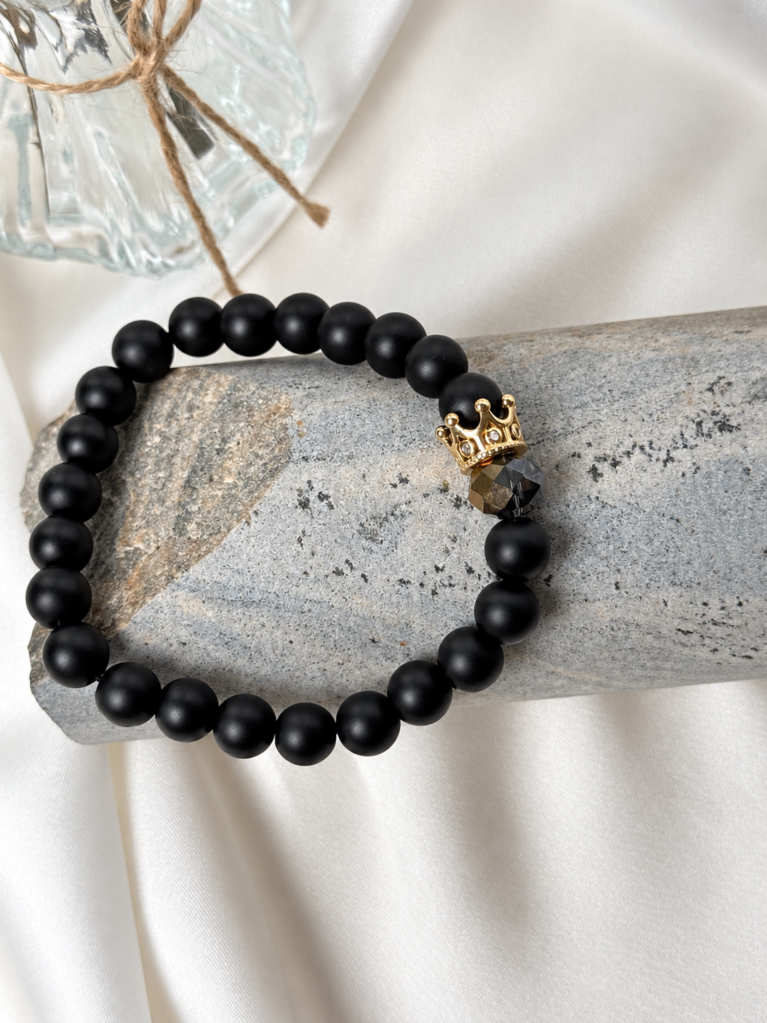 A handmade bracelet featuring matte onyx stone, a dark faceted accent and a gold-tone crown detail. An elegant design with a distinctive royal touch, perfect worn alone or stacked with other bracelets.

Stone size: 8 mm
Bracelet size: approximately 18 cm
