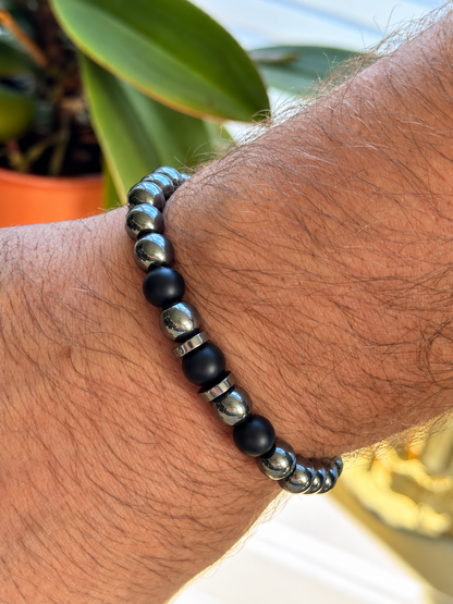 A handmade bracelet featuring polished hematite stone and matte onyx accents. A striking contrast of metallic shine and deep black tones, perfect worn alone or stacked with other bracelets.

Stone size: 8 mm
Bracelet size: approximately 18–18.5 cm