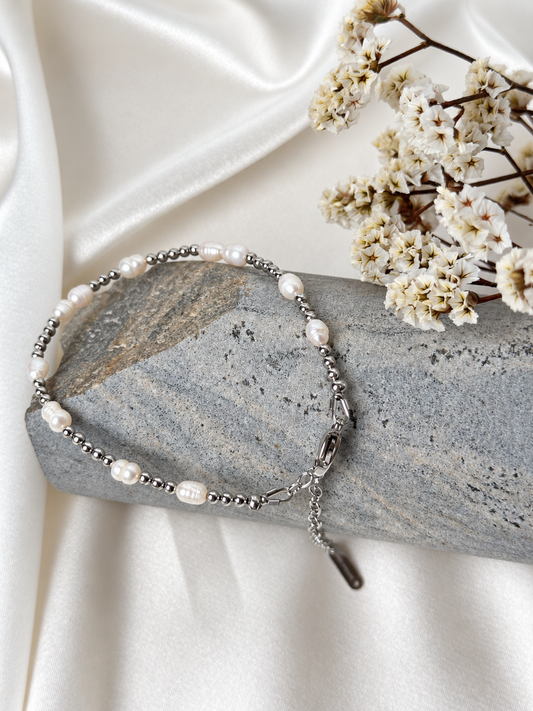 A handmade bracelet featuring lustrous white pearls and polished stainless steel beads. A delicate, timeless design, perfect worn alone or layered with other bracelets.

Bracelet length: approximately 17 cm + 4 cm extension chain