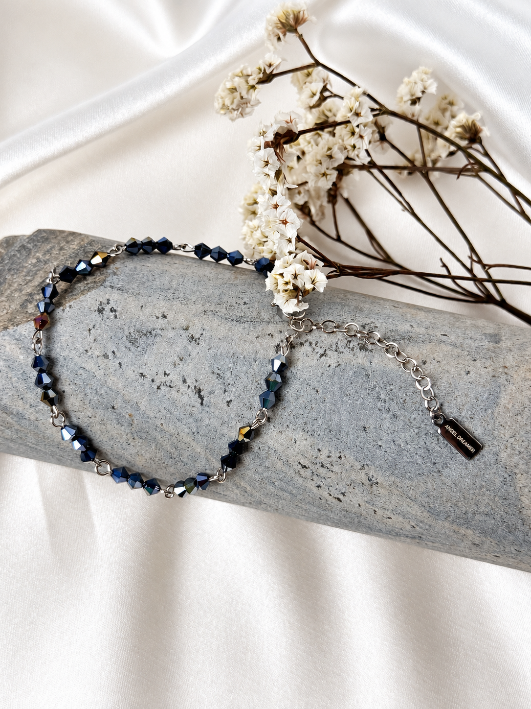 A handmade bracelet featuring faceted glass crystal beads in deep blue with iridescent reflections, linked with stainless steel details. A delicate, elegant design, perfect worn alone or layered with other bracelets.

Bead size: 4 mm
Bracelet length: approximately 18 cm + 4 cm extension chain
